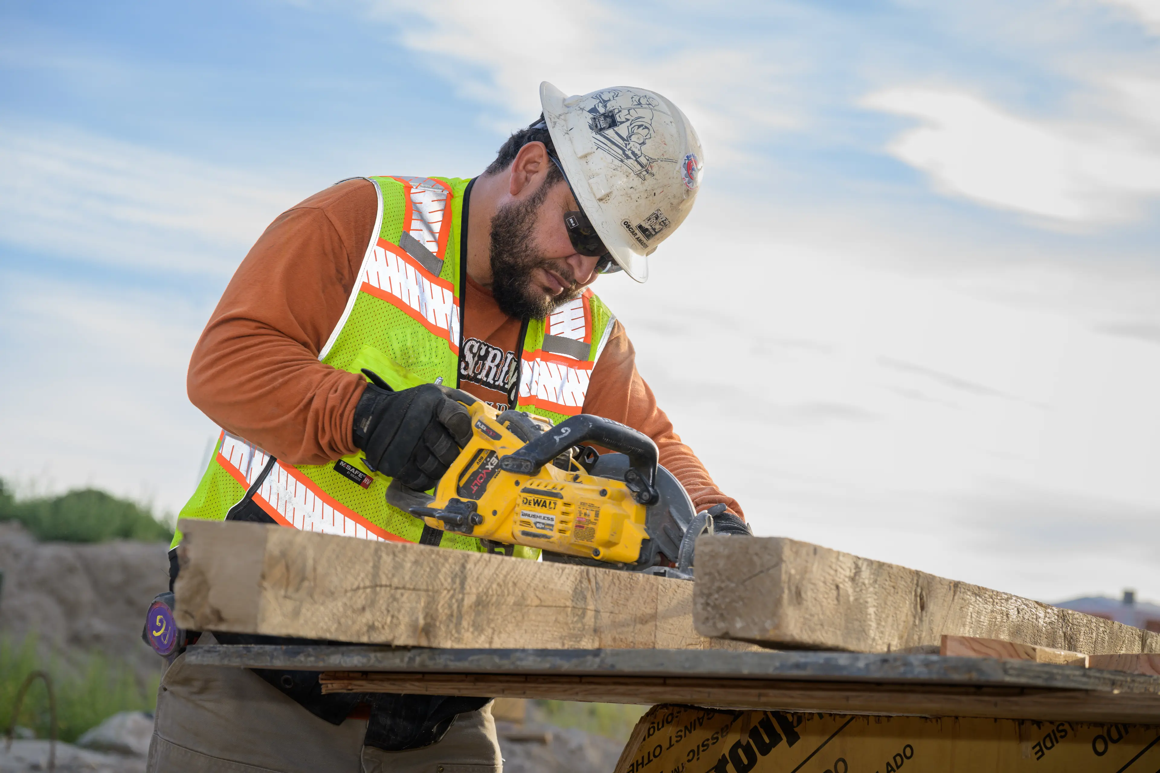 man cutting wood with saw